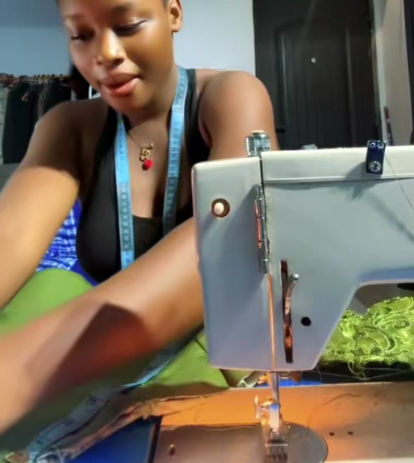 Glory, the designer, at her sewing machine